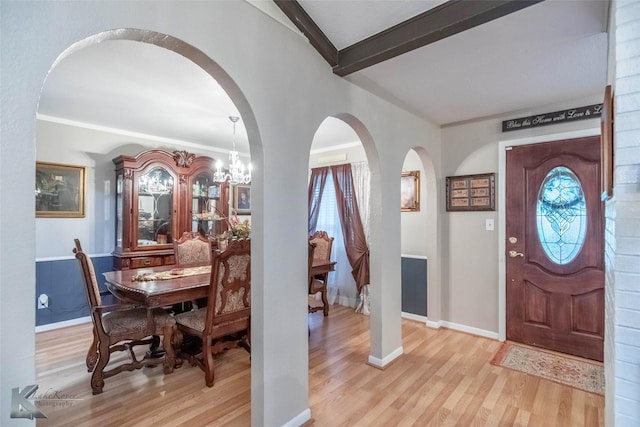 entrance foyer with arched walkways, wood finished floors, and baseboards