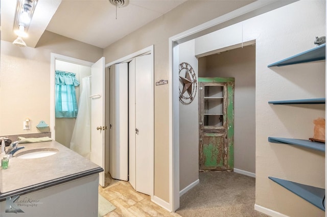 bathroom with a shower with shower curtain, vanity, and baseboards