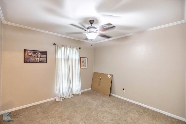 spare room featuring light carpet, baseboards, crown molding, and a ceiling fan