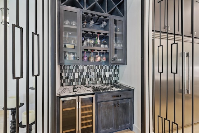 bar with backsplash, beverage cooler, and indoor bar
