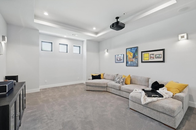 carpeted living room with recessed lighting, a tray ceiling, and baseboards