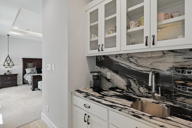 bar with tasteful backsplash, visible vents, pendant lighting, and a sink