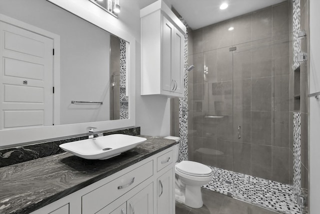 bathroom featuring recessed lighting, toilet, vanity, and a stall shower