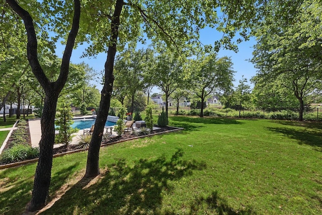 exterior space with a yard, fence, and a pool