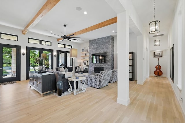 living area with recessed lighting, a fireplace, light wood-style flooring, beamed ceiling, and ceiling fan with notable chandelier