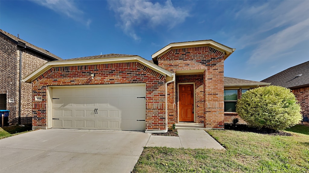 view of front of home with a garage, brick siding, and driveway