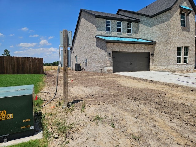 213 Pilot Dr, Caddo Mills, TX 75135 - view of side of home with a garage, driveway, central AC, and stone siding