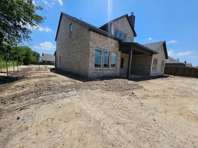 213 Pilot Dr, Caddo Mills, TX 75135 - back of property with a chimney and brick siding