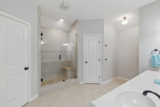 202 Hill Valley Dr, Stephenville, TX 76401 - bathroom featuring visible vents, baseboards, a sink, vaulted ceiling, and a stall shower