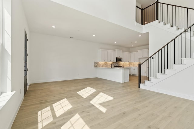 15712 Millwood Trl, Frisco, TX 75033 - unfurnished living room with recessed lighting, light wood-style flooring, and stairs