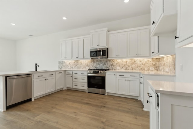 15712 Millwood Trl, Frisco, TX 75033 - kitchen with decorative backsplash, white cabinetry, stainless steel appliances, and light countertops
