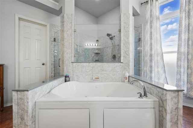 bathroom with a shower stall and a jetted tub