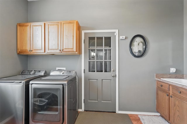 washroom with washer and dryer, a sink, and cabinet space