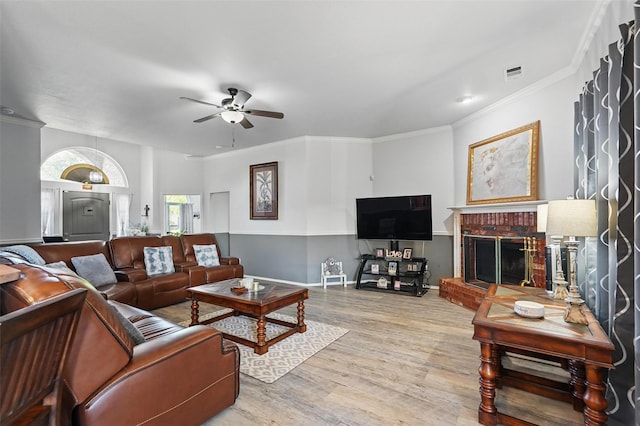 living area featuring visible vents, wood finished floors, ornamental molding, and ceiling fan