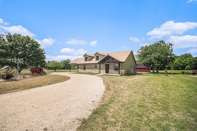 view of front facade with board and batten siding, a front yard, and curved driveway