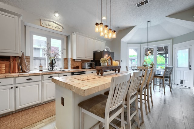 3419 Willowcreek Dr, Sunnyvale, TX 75182 - kitchen with a textured ceiling, a sink, visible vents, freestanding refrigerator, and backsplash