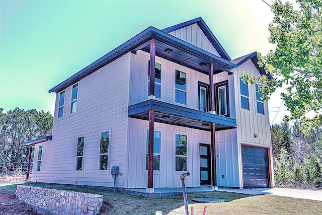 view of front facade featuring board and batten siding, an attached garage, concrete driveway, and a balcony