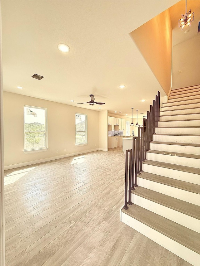 stairway with wood finished floors, baseboards, a ceiling fan, and recessed lighting