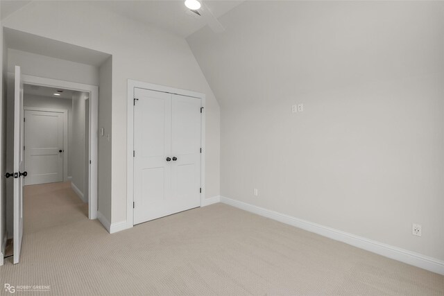 916 Aaron Ln, Benton, LA 71006 - unfurnished bedroom with light carpet, lofted ceiling, and a closet