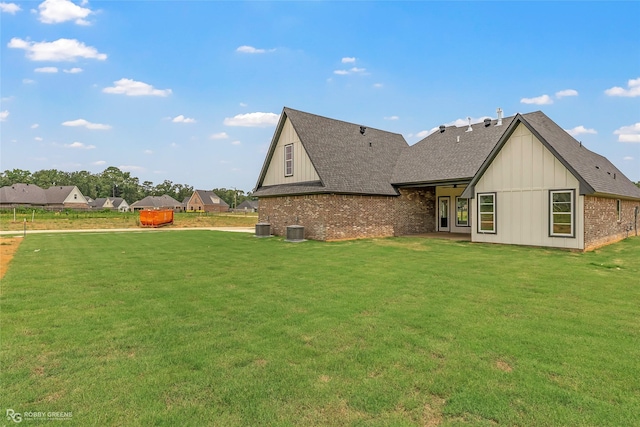916 Aaron Ln, Benton, LA 71006 - rear view of property featuring a shingled roof, board and batten siding, brick siding, and a lawn