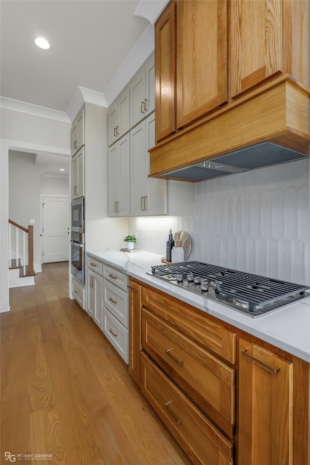 916 Aaron Ln, Benton, LA 71006 - kitchen with appliances with stainless steel finishes, light wood-type flooring, tasteful backsplash, light countertops, and recessed lighting