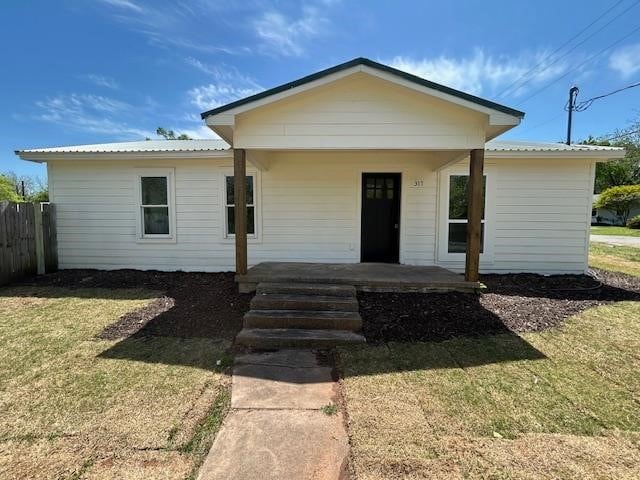 317 W Elm St, Whitewright, TX 75491 - view of front facade with covered porch and a metal roof
