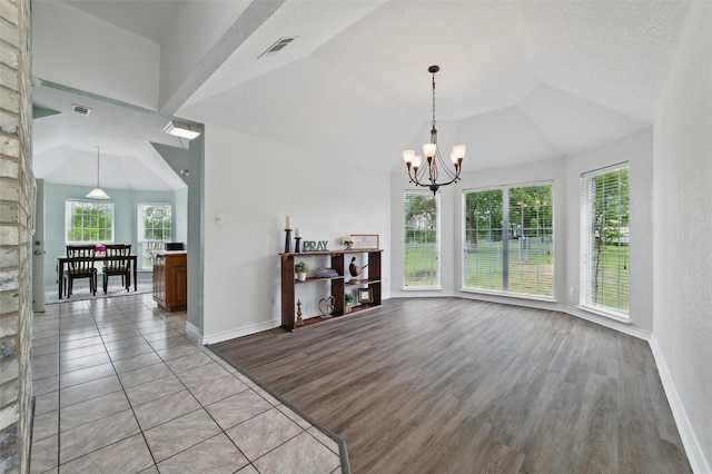 dining area with visible vents, light wood finished floors, lofted ceiling, and a chandelier