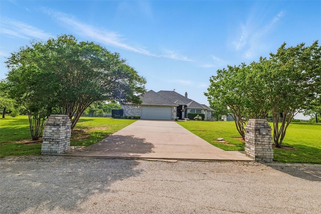view of front of house featuring concrete driveway, a garage, and a front lawn