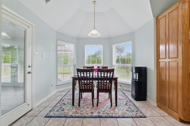 dining area featuring baseboards, light tile patterned floors, a healthy amount of sunlight, and vaulted ceiling