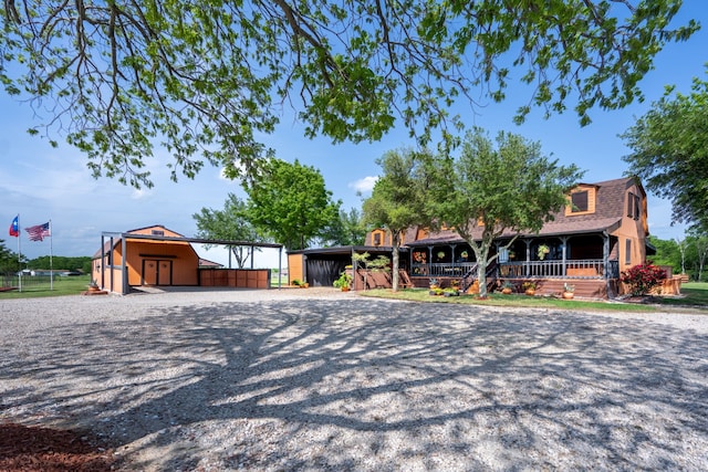 12282 Fm 1392, Terrell, TX 75160 - view of front facade with a gambrel roof, an outbuilding, and covered porch