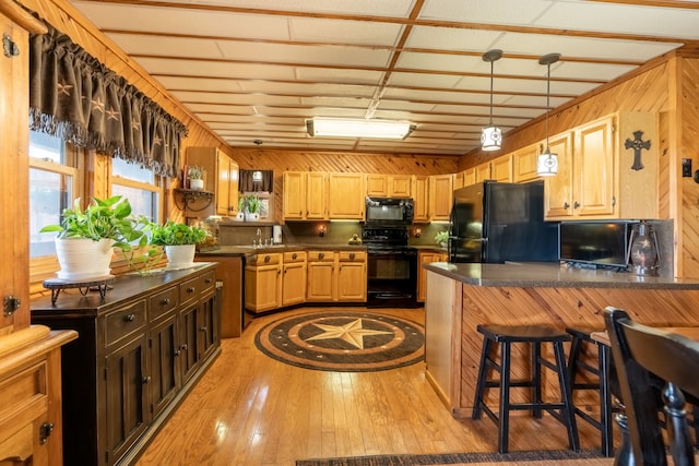 12282 Fm 1392, Terrell, TX 75160 - kitchen with dark countertops, wood walls, black appliances, and a peninsula