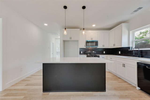 kitchen with white cabinets, a center island, black appliances, and backsplash
