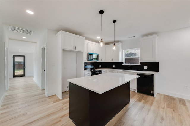 kitchen with stainless steel microwave, range with gas stovetop, white cabinetry, visible vents, and dishwasher
