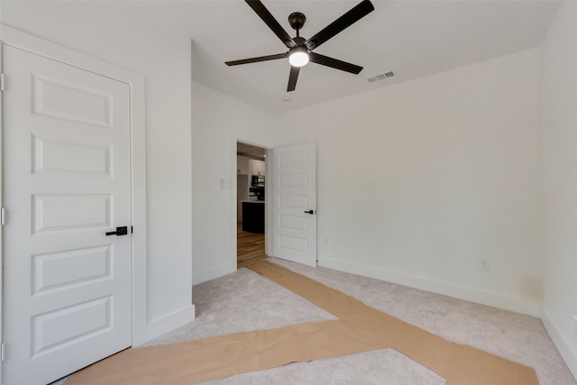 unfurnished bedroom with ceiling fan, visible vents, baseboards, and carpet