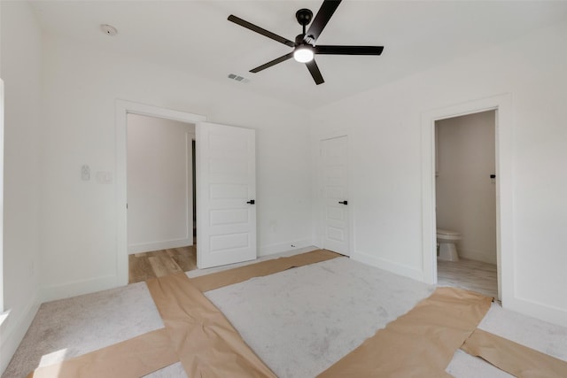 unfurnished bedroom with ensuite bathroom, baseboards, visible vents, and a ceiling fan