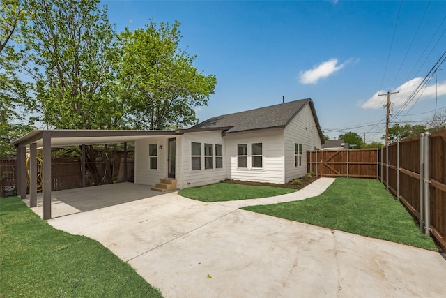 back of property featuring fence private yard, driveway, entry steps, a gate, and a lawn