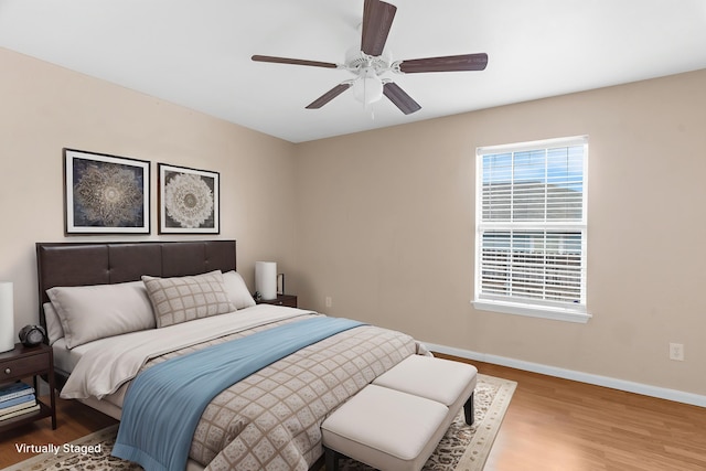 bedroom featuring wood finished floors, baseboards, and ceiling fan