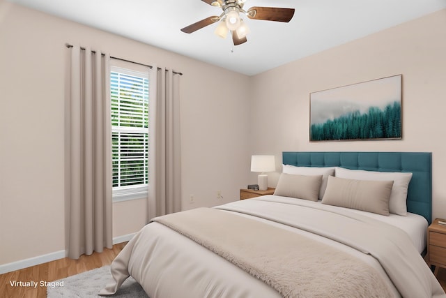 bedroom featuring ceiling fan, baseboards, and wood finished floors