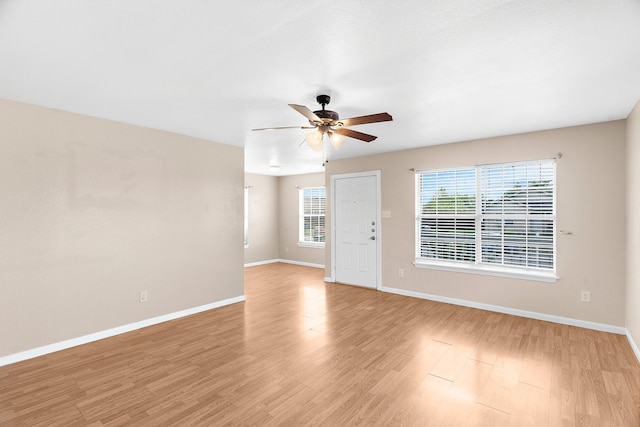 unfurnished room featuring light wood-style flooring, a ceiling fan, and baseboards