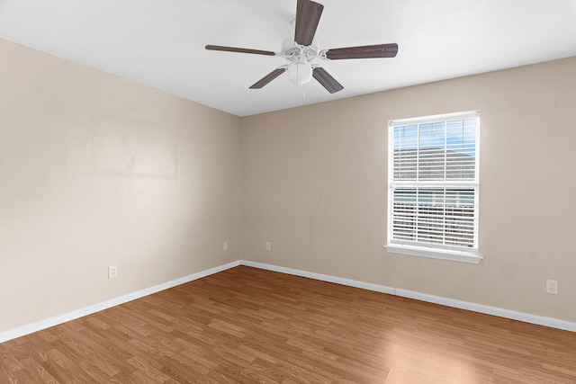 spare room featuring baseboards, a ceiling fan, and wood finished floors