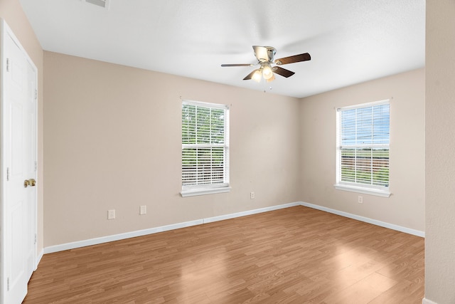 spare room featuring ceiling fan, baseboards, and wood finished floors