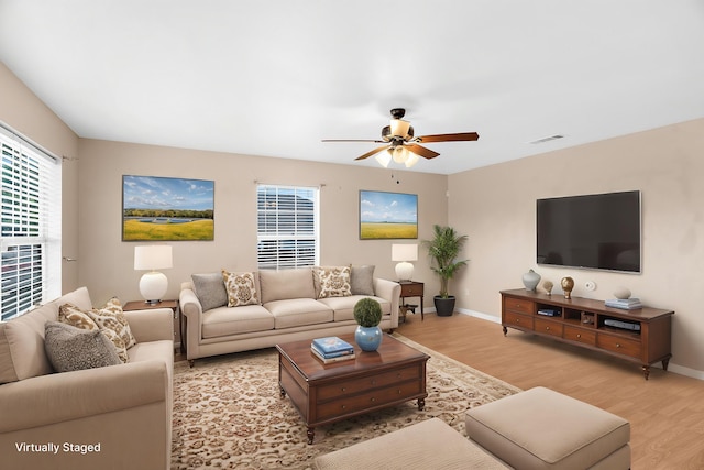 living room featuring ceiling fan, baseboards, visible vents, and light wood-style flooring