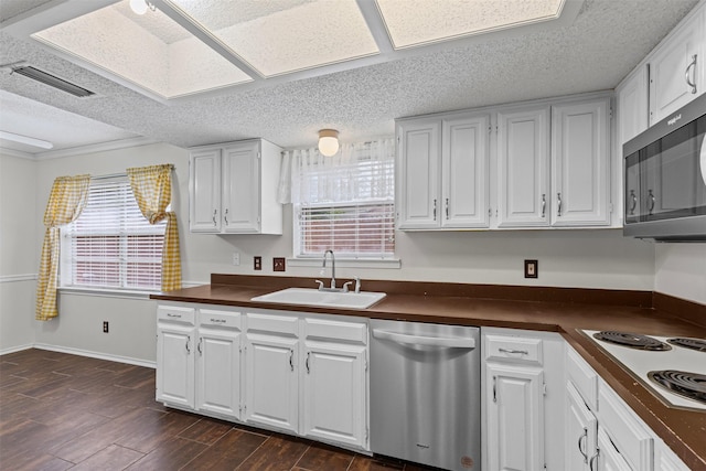 3206 Knights Haven Ln, Garland, TX 75044 - kitchen with appliances with stainless steel finishes, a sink, dark countertops, white cabinets, and a textured ceiling