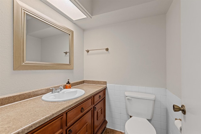 3206 Knights Haven Ln, Garland, TX 75044 - half bathroom featuring toilet, wainscoting, vanity, and tile walls