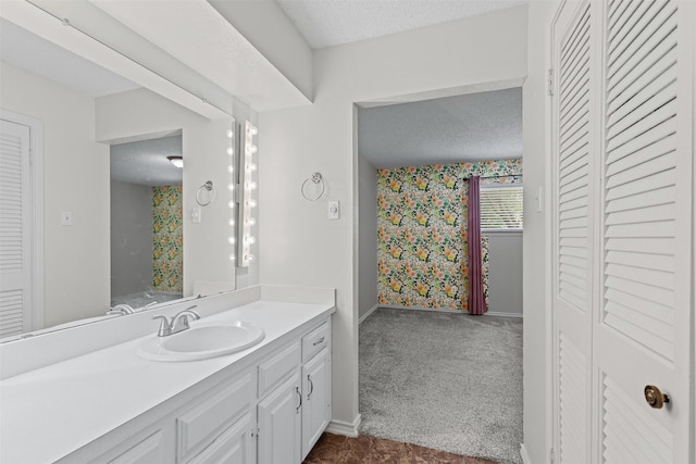 3206 Knights Haven Ln, Garland, TX 75044 - bathroom featuring a textured ceiling, wallpapered walls, a closet, baseboards, and vanity