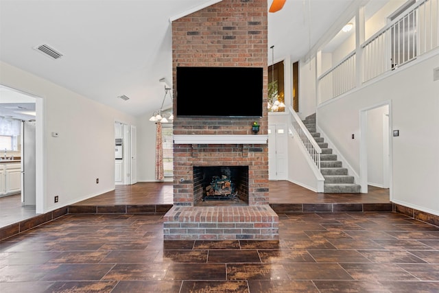 3206 Knights Haven Ln, Garland, TX 75044 - unfurnished living room featuring baseboards, a fireplace, high vaulted ceiling, stairs, and wood finished floors