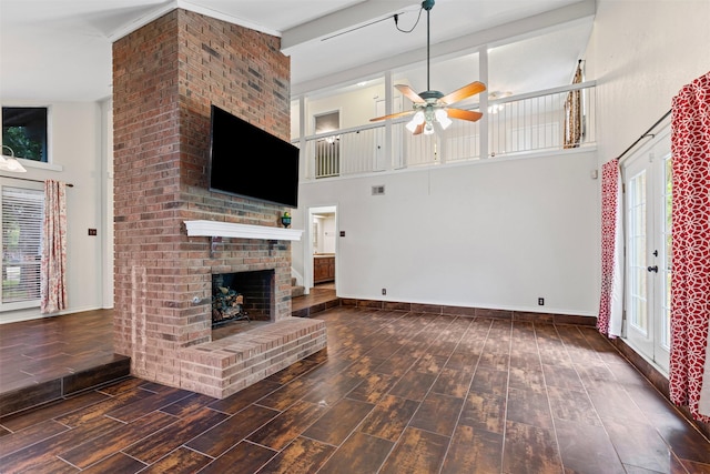 3206 Knights Haven Ln, Garland, TX 75044 - unfurnished living room with a high ceiling, ceiling fan, wood finished floors, a fireplace, and baseboards