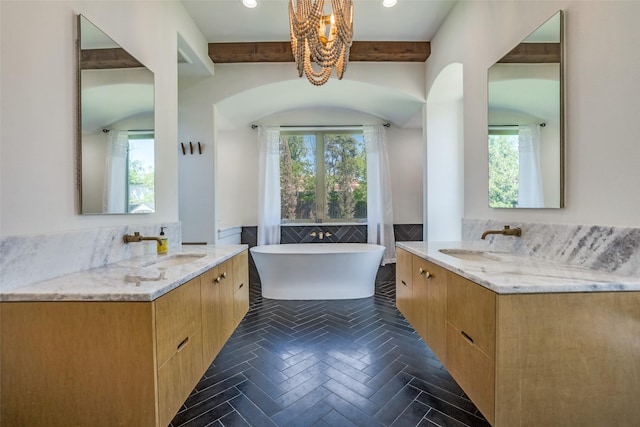 full bath with tile walls, a healthy amount of sunlight, and a sink
