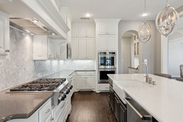 kitchen with stainless steel appliances, visible vents, arched walkways, custom exhaust hood, and white cabinetry