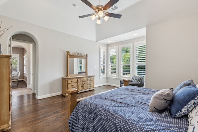 bedroom featuring arched walkways, dark wood finished floors, baseboards, and visible vents